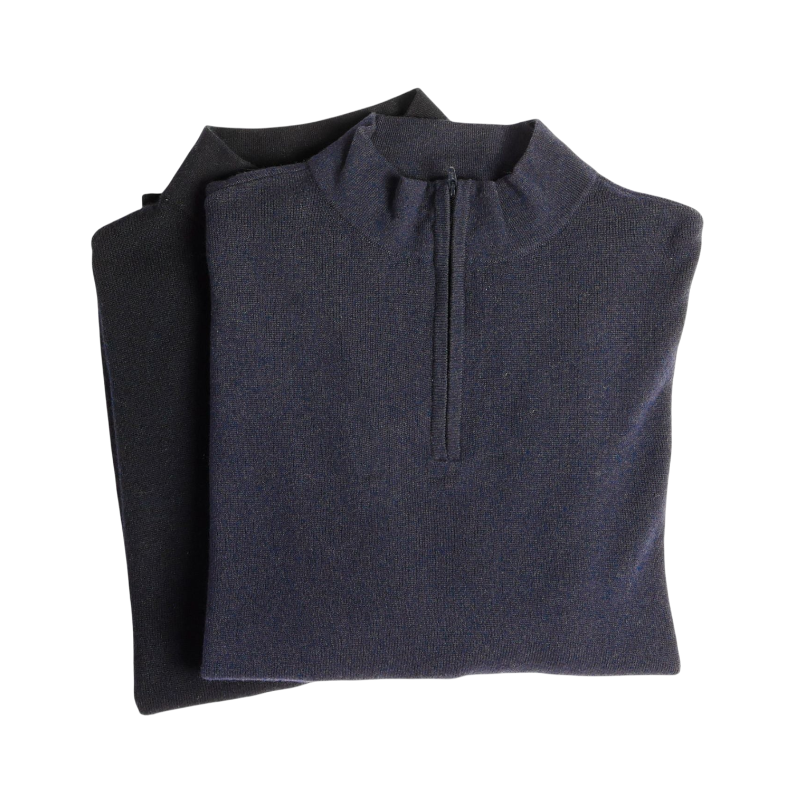 A man with dark hair and a short beard is wearing a navy blue Men's Quarter Zip Sweater from Cozy Earth paired with beige pants. He stands with his hands in his pockets against a plain white background, looking to his right with a slight smile. |Color:Eclipse