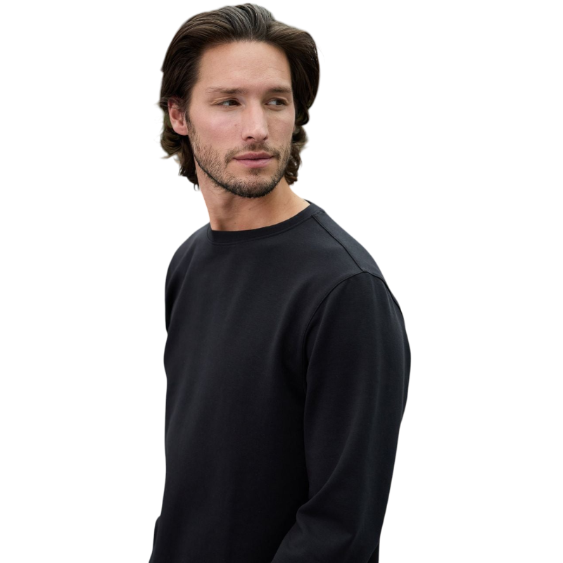 A man is wearing the Men's StretchTech Crewneck sweatshirt from Cozy Earth, paired with matching sweatpants. He stands against a plain white background with short brown hair, looking forward with a neutral expression. |Color:Coal Heather