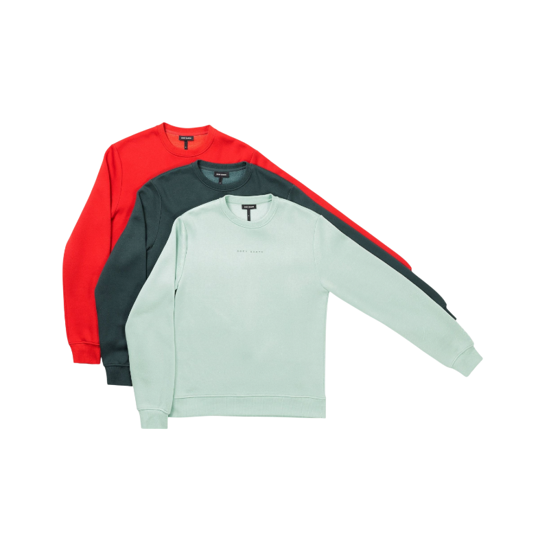 A man with short brown hair is wearing a dark green Men's CityScape Crewneck from Cozy Earth, featuring the words "COLD EARTH" printed on it. He is gazing slightly to the side against a plain white background. |Color:Spruce