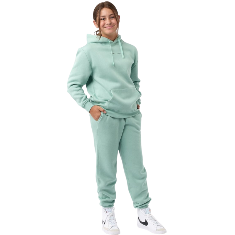 A young child with long blonde hair smiles while wearing a navy blue Kid's CityScape Hoodie by Cozy Earth and matching pants. She has two hair ties, one pink and one blue. The background is plain white. |Color:Eclipse