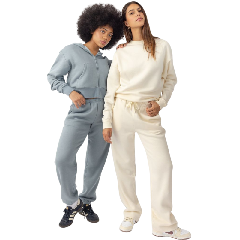A person with curly hair models the Cozy Earth Women's CityScape Crewneck and matching pants in light pink against a plain white backdrop. |Color:Peony