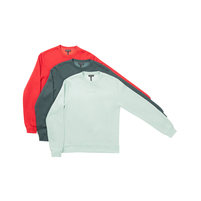 A man with short brown hair is wearing a dark green Men's CityScape Crewneck from Cozy Earth, featuring the words "COLD EARTH" printed on it. He is gazing slightly to the side against a plain white background. |Color:Spruce