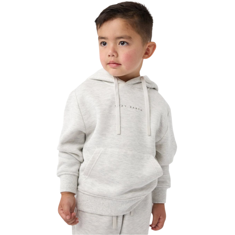 A young boy with short brown hair stands against a white background, wearing the Cozy Earth Kid's CityScape Hoodie, a light gray piece with subtle text on it, paired with matching sweatpants. He gazes to the side with a thoughtful expression. |Color:Heather Grey