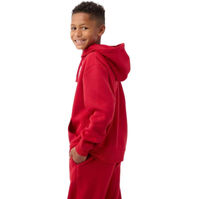 A young child with long blonde hair smiles while wearing a navy blue Kid's CityScape Hoodie by Cozy Earth and matching pants. She has two hair ties, one pink and one blue. The background is plain white. |Color:Eclipse