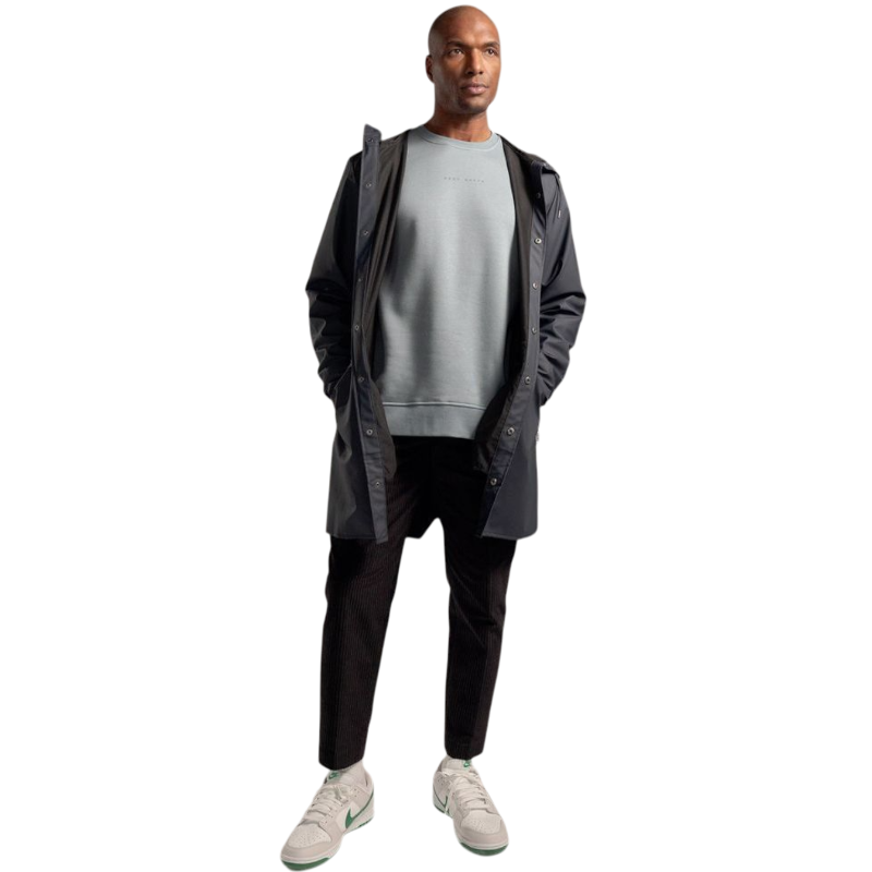 A man with short brown hair is wearing a dark green Men's CityScape Crewneck from Cozy Earth, featuring the words "COLD EARTH" printed on it. He is gazing slightly to the side against a plain white background. |Color:Spruce
