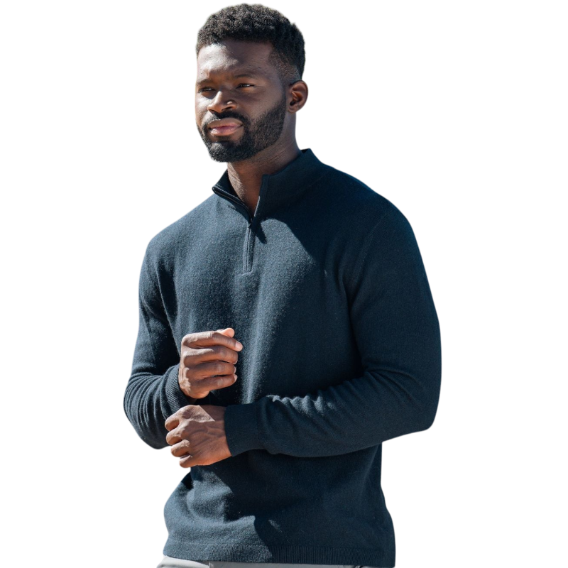 A man with dark hair and a short beard is wearing a navy blue Men's Quarter Zip Sweater from Cozy Earth paired with beige pants. He stands with his hands in his pockets against a plain white background, looking to his right with a slight smile. |Color:Eclipse