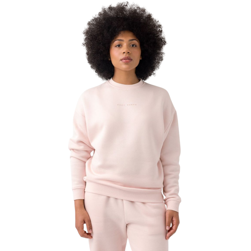 A person with curly hair models the Cozy Earth Women's CityScape Crewneck and matching pants in light pink against a plain white backdrop. |Color:Peony