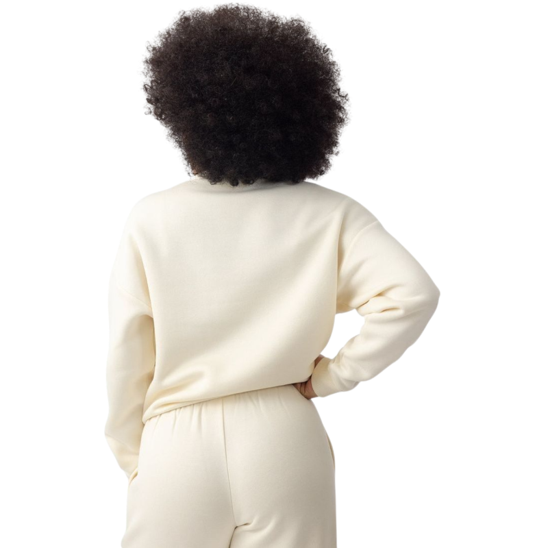 A person with curly hair models the Cozy Earth Women's CityScape Crewneck and matching pants in light pink against a plain white backdrop. |Color:Peony