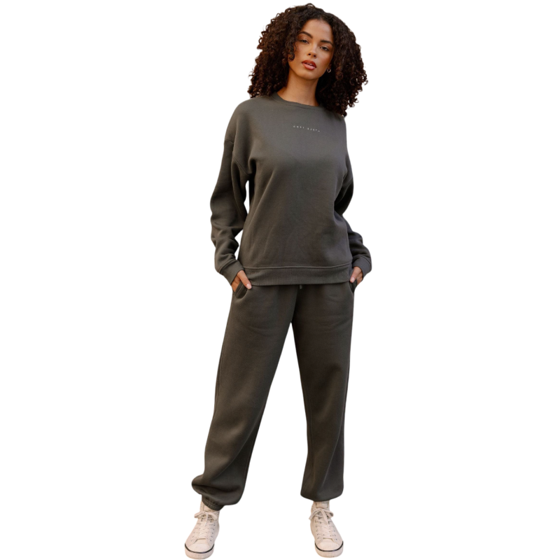 A person with curly hair models the Cozy Earth Women's CityScape Crewneck and matching pants in light pink against a plain white backdrop. |Color:Peony