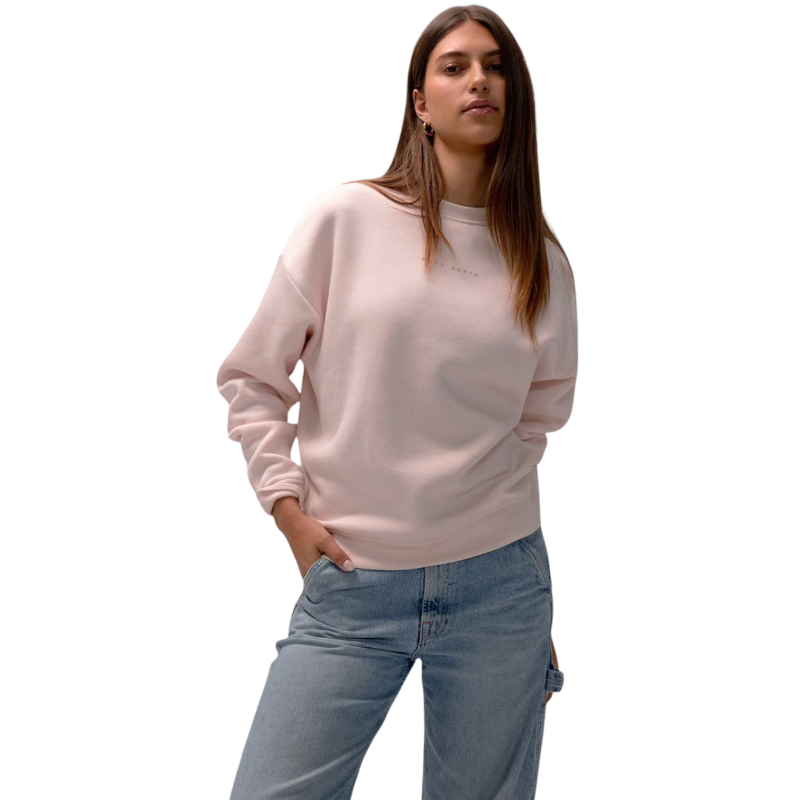 A person with curly hair models the Cozy Earth Women's CityScape Crewneck and matching pants in light pink against a plain white backdrop. |Color:Peony