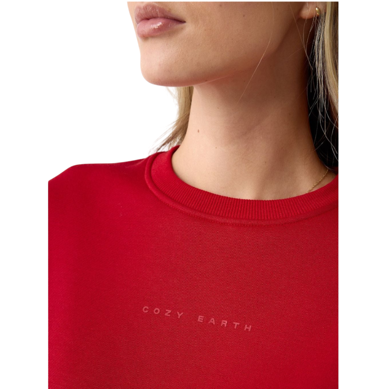 A person with curly hair models the Cozy Earth Women's CityScape Crewneck and matching pants in light pink against a plain white backdrop. |Color:Peony