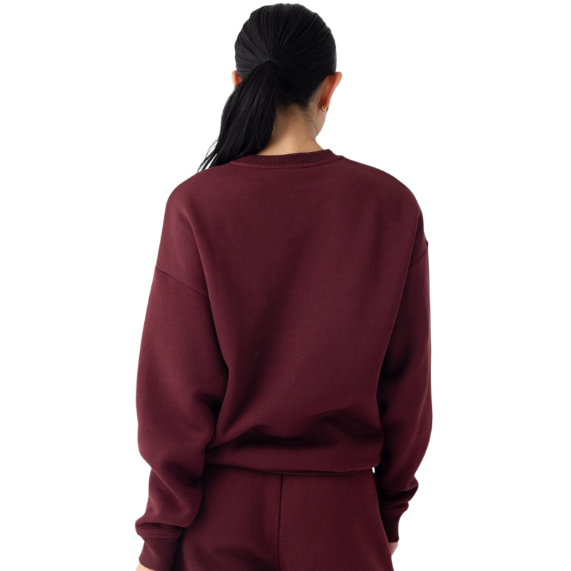 A person with curly hair models the Cozy Earth Women's CityScape Crewneck and matching pants in light pink against a plain white backdrop. |Color:Peony