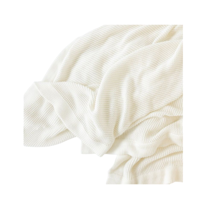 Ivory Cloud Knit Baby Blanket draped over crib |Color:Ivory