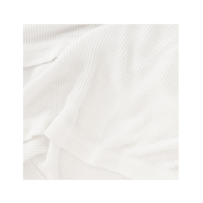 Ivory Cloud Knit Baby Blanket draped over crib |Color:Ivory