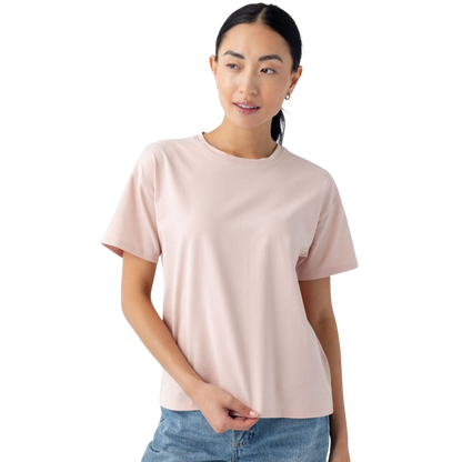 A person with long dark hair is wearing a light pink Women's All Day Tee from Cozy Earth and jeans. They are looking slightly to the side with a neutral expression, against a plain white background. |Color:Dusty Rose