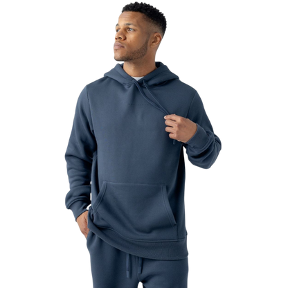 A man wearing a Cozy Earth Men's CityScape Hoodie and matching jogger pants stands against a white background. He is looking off to the side while casually holding the drawstring of his hoodie. |Color:Eclipse