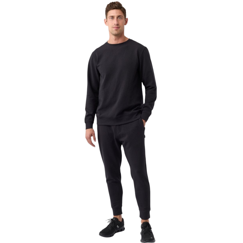 A man is wearing the Men's StretchTech Crewneck sweatshirt from Cozy Earth, paired with matching sweatpants. He stands against a plain white background with short brown hair, looking forward with a neutral expression. |Color:Coal Heather
