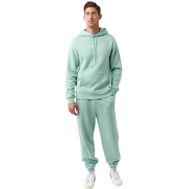 A person with curly hair is wearing a Cozy Earth Men's CityScape Hoodie in dark green and standing against a plain white background, with their hands together. |Color:Spruce