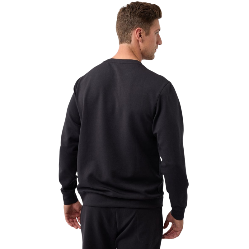 A man is wearing the Men's StretchTech Crewneck sweatshirt from Cozy Earth, paired with matching sweatpants. He stands against a plain white background with short brown hair, looking forward with a neutral expression. |Color:Coal Heather