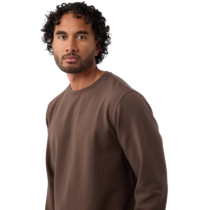 A man is wearing the Men's StretchTech Crewneck sweatshirt from Cozy Earth, paired with matching sweatpants. He stands against a plain white background with short brown hair, looking forward with a neutral expression. |Color:Coal Heather