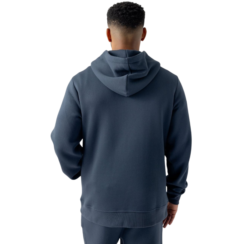 A person with curly hair is wearing a Cozy Earth Men's CityScape Hoodie in dark green and standing against a plain white background, with their hands together. |Color:Spruce