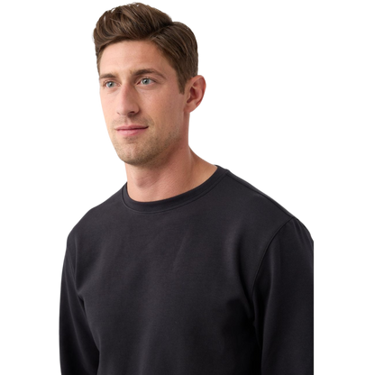 A man is wearing the Men's StretchTech Crewneck sweatshirt from Cozy Earth, paired with matching sweatpants. He stands against a plain white background with short brown hair, looking forward with a neutral expression. |Color:Coal Heather