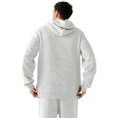 A person with curly hair is wearing a Cozy Earth Men's CityScape Hoodie in dark green and standing against a plain white background, with their hands together. |Color:Spruce