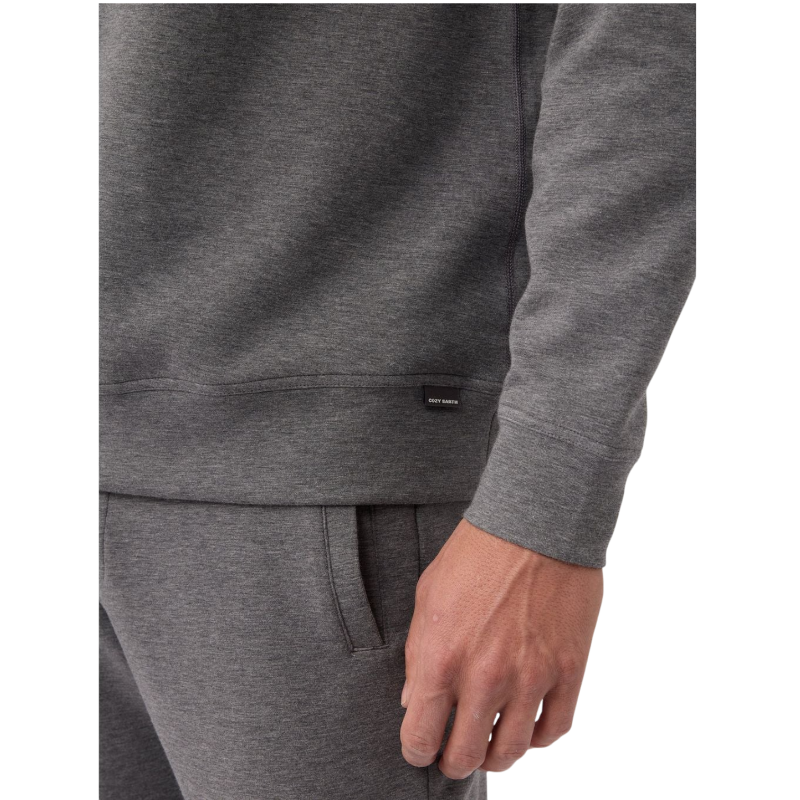 A man is wearing the Men's StretchTech Crewneck sweatshirt from Cozy Earth, paired with matching sweatpants. He stands against a plain white background with short brown hair, looking forward with a neutral expression. |Color:Coal Heather