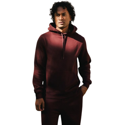 A person with curly hair is wearing a Cozy Earth Men's CityScape Hoodie in dark green and standing against a plain white background, with their hands together. |Color:Spruce