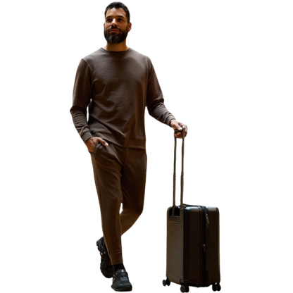 A man is wearing the Men's StretchTech Crewneck sweatshirt from Cozy Earth, paired with matching sweatpants. He stands against a plain white background with short brown hair, looking forward with a neutral expression. |Color:Coal Heather