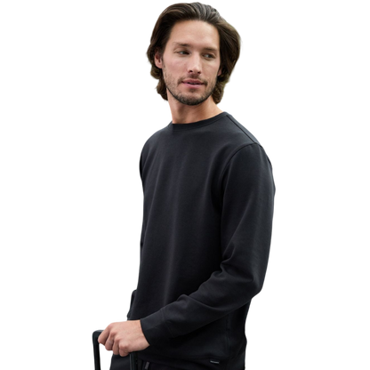 A man is wearing the Men's StretchTech Crewneck sweatshirt from Cozy Earth, paired with matching sweatpants. He stands against a plain white background with short brown hair, looking forward with a neutral expression. |Color:Coal Heather