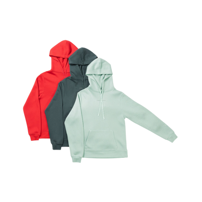 A person with curly hair is wearing a Cozy Earth Men's CityScape Hoodie in dark green and standing against a plain white background, with their hands together. |Color:Spruce