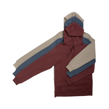 A person with curly hair is wearing a Cozy Earth Men's CityScape Hoodie in dark green and standing against a plain white background, with their hands together. |Color:Spruce