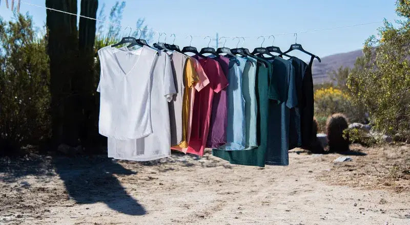 A row of high-quality t-shirts in earth tones hanging outdoors