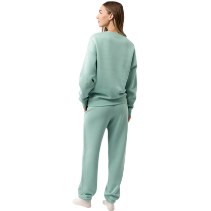 A young boy with blond hair is wearing the Cozy Earth Kid's CityScape Crewneck sweatshirt along with matching pants. He is standing, smiling, and looking slightly to the side against a plain white background. |Color:Eclipse
