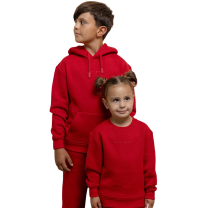 A young boy with blond hair is wearing the Cozy Earth Kid's CityScape Crewneck sweatshirt along with matching pants. He is standing, smiling, and looking slightly to the side against a plain white background. |Color:Eclipse