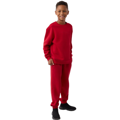 A young boy with blond hair is wearing the Cozy Earth Kid's CityScape Crewneck sweatshirt along with matching pants. He is standing, smiling, and looking slightly to the side against a plain white background. |Color:Eclipse