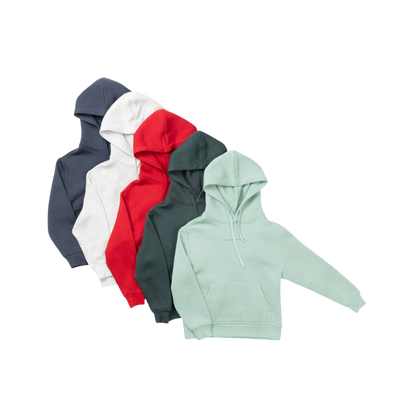 A young child with long blonde hair smiles while wearing a navy blue Kid's CityScape Hoodie by Cozy Earth and matching pants. She has two hair ties, one pink and one blue. The background is plain white. |Color:Eclipse