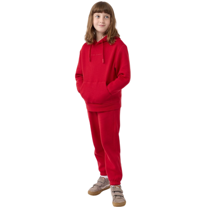 A young child with long blonde hair smiles while wearing a navy blue Kid's CityScape Hoodie by Cozy Earth and matching pants. She has two hair ties, one pink and one blue. The background is plain white. |Color:Eclipse