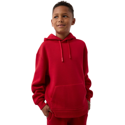 A young child with long blonde hair smiles while wearing a navy blue Kid's CityScape Hoodie by Cozy Earth and matching pants. She has two hair ties, one pink and one blue. The background is plain white. |Color:Eclipse