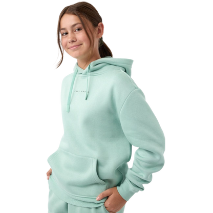 A young child with long blonde hair smiles while wearing a navy blue Kid's CityScape Hoodie by Cozy Earth and matching pants. She has two hair ties, one pink and one blue. The background is plain white. |Color:Eclipse