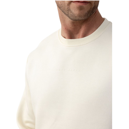 A man with short brown hair is wearing a dark green Men's CityScape Crewneck from Cozy Earth, featuring the words "COLD EARTH" printed on it. He is gazing slightly to the side against a plain white background. |Color:Spruce