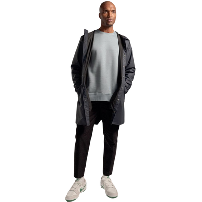 A man with short brown hair is wearing a dark green Men's CityScape Crewneck from Cozy Earth, featuring the words "COLD EARTH" printed on it. He is gazing slightly to the side against a plain white background. |Color:Spruce