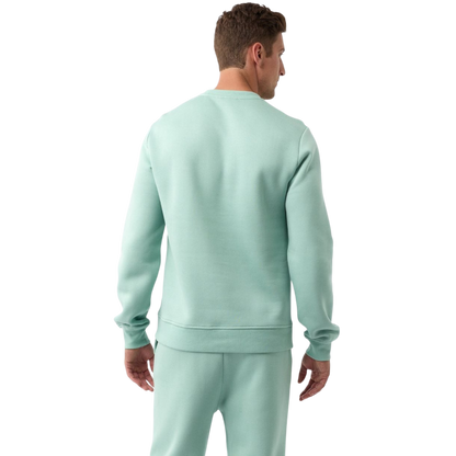 A man with short brown hair is wearing a dark green Men's CityScape Crewneck from Cozy Earth, featuring the words "COLD EARTH" printed on it. He is gazing slightly to the side against a plain white background. |Color:Spruce