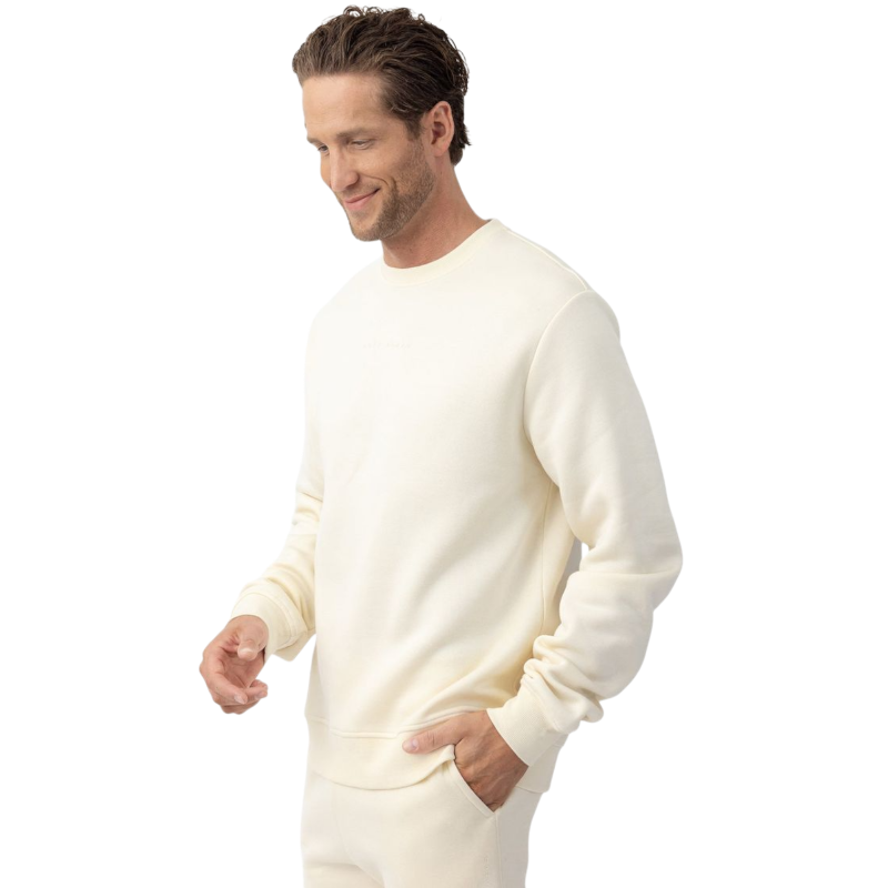 A man with short brown hair is wearing a dark green Men's CityScape Crewneck from Cozy Earth, featuring the words "COLD EARTH" printed on it. He is gazing slightly to the side against a plain white background. |Color:Spruce