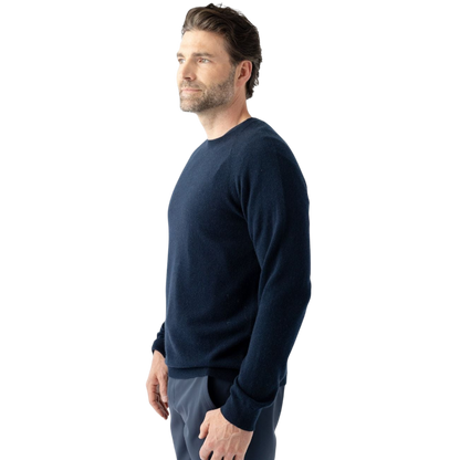 A man with dark hair and a beard stands casually with his hands in his pockets. He is wearing the Cozy Earth Men's Crewneck Sweater in navy blue, paired with gray pants. He looks at the camera with a neutral expression, set against a plain white background. |Color:Eclipse
