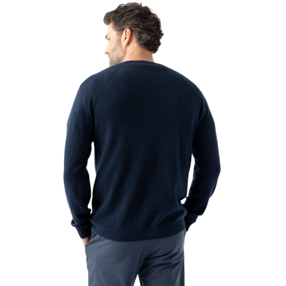 A man with dark hair and a beard stands casually with his hands in his pockets. He is wearing the Cozy Earth Men's Crewneck Sweater in navy blue, paired with gray pants. He looks at the camera with a neutral expression, set against a plain white background. |Color:Eclipse