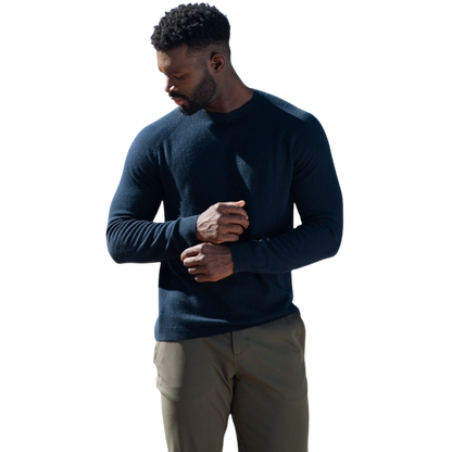 A man with dark hair and a beard stands casually with his hands in his pockets. He is wearing the Cozy Earth Men's Crewneck Sweater in navy blue, paired with gray pants. He looks at the camera with a neutral expression, set against a plain white background. |Color:Eclipse