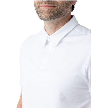 A person with short, light brown hair is wearing the Men's Everyday Polo by Cozy Earth in a light gray shade, paired with light beige pants. They are standing and slightly looking over their left shoulder with a neutral expression against a plain white background. |Color:Stone