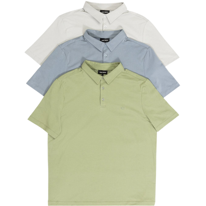 A person with short, light brown hair is wearing the Men's Everyday Polo by Cozy Earth in a light gray shade, paired with light beige pants. They are standing and slightly looking over their left shoulder with a neutral expression against a plain white background. |Color:Stone
